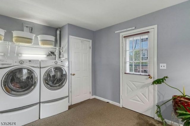 washroom featuring washing machine and clothes dryer, dark colored carpet, baseboards, and laundry area
