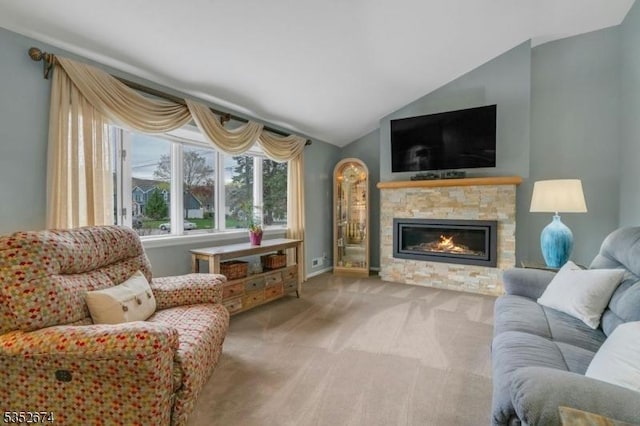 carpeted living area with vaulted ceiling, baseboards, and a stone fireplace