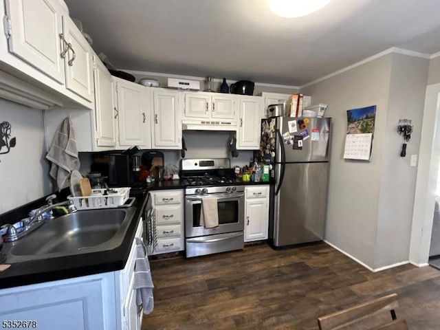 kitchen featuring white cabinets, dark countertops, appliances with stainless steel finishes, a sink, and under cabinet range hood