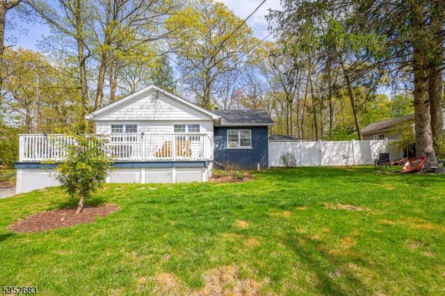 back of property featuring a lawn, fence, and a deck