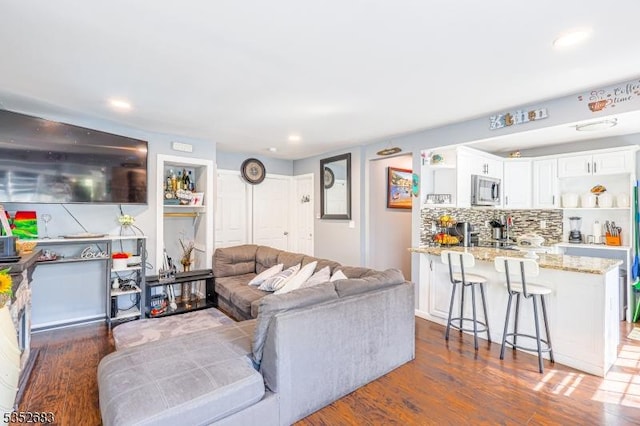 living area featuring recessed lighting and dark wood-style flooring