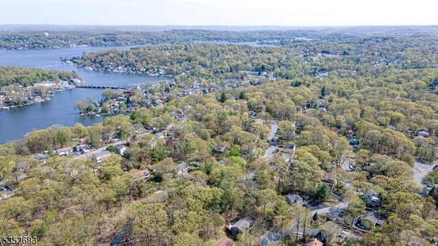 birds eye view of property featuring a water view and a wooded view