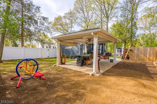 exterior space with a fenced backyard, ceiling fan, an outbuilding, and a storage shed