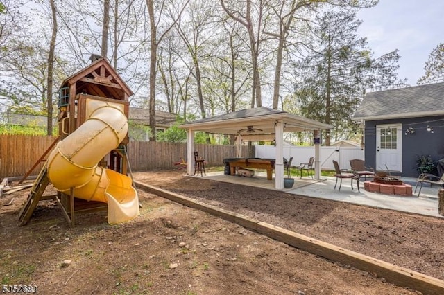 view of play area with a gazebo, a fenced backyard, a fire pit, and a patio area
