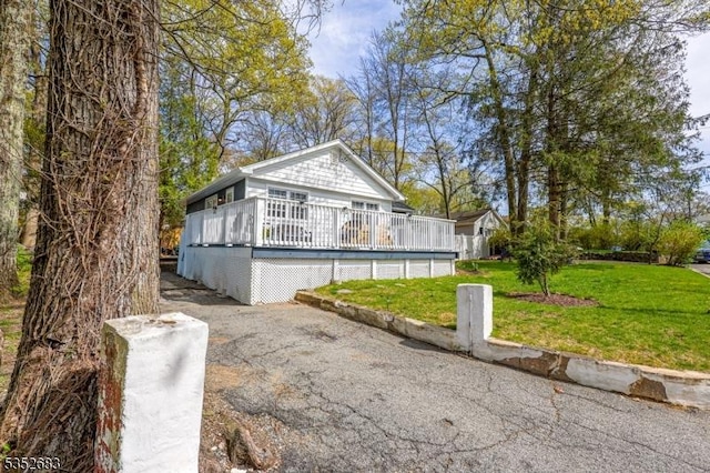 view of side of home with a lawn and a deck