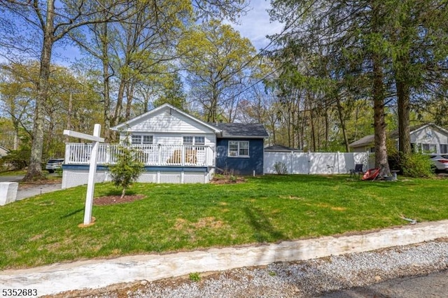 bungalow-style home with a deck, fence, and a front yard