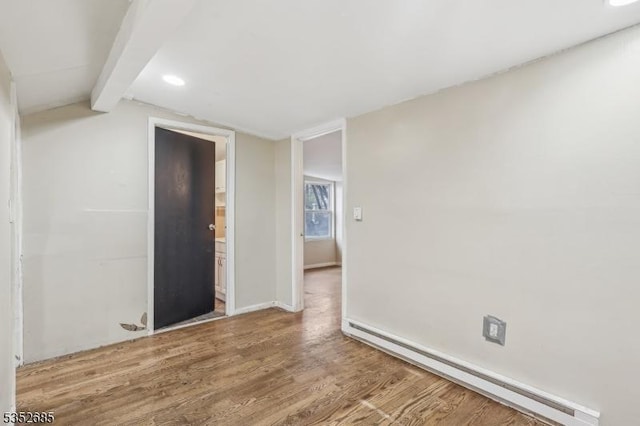 unfurnished room with baseboard heating, wood finished floors, baseboards, lofted ceiling with beams, and recessed lighting