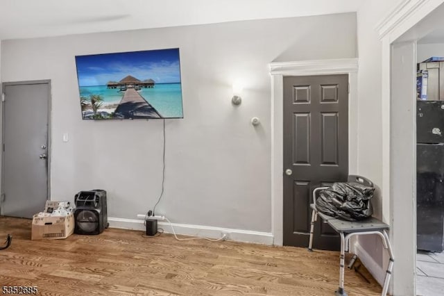 living area with baseboards and wood finished floors