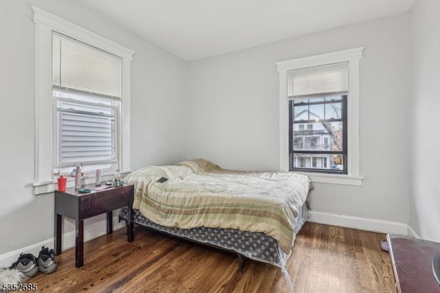 bedroom with baseboards and wood finished floors