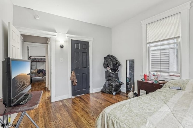 bedroom with baseboards and wood finished floors