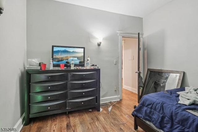 bedroom featuring baseboards and wood finished floors