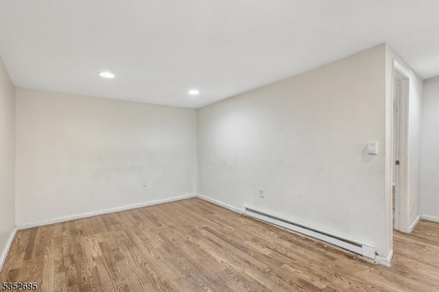 spare room featuring baseboards, recessed lighting, wood finished floors, and baseboard heating