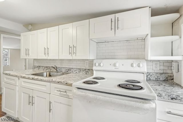 kitchen featuring white cabinetry, tasteful backsplash, a sink, and electric stove