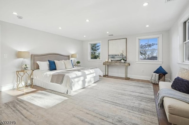 bedroom with recessed lighting, wood finished floors, visible vents, and baseboards