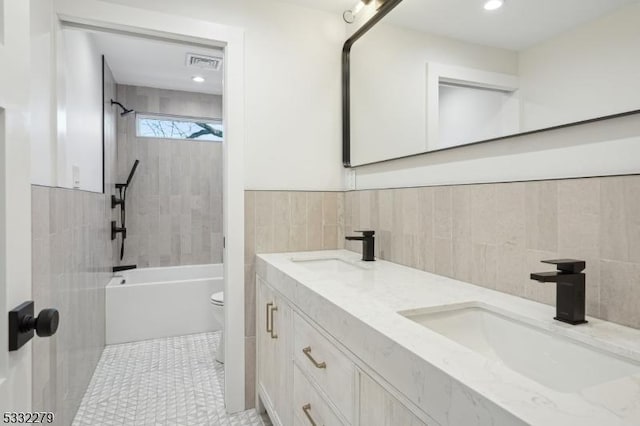 bathroom featuring double vanity, visible vents, shower / bath combination, and a sink