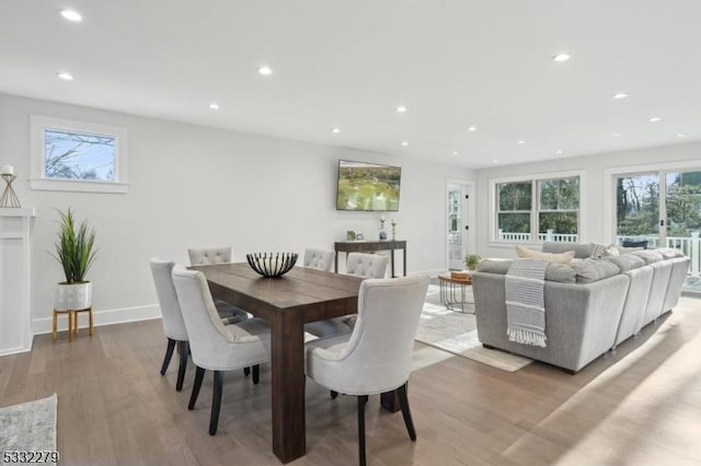 dining area with baseboards, wood finished floors, and recessed lighting