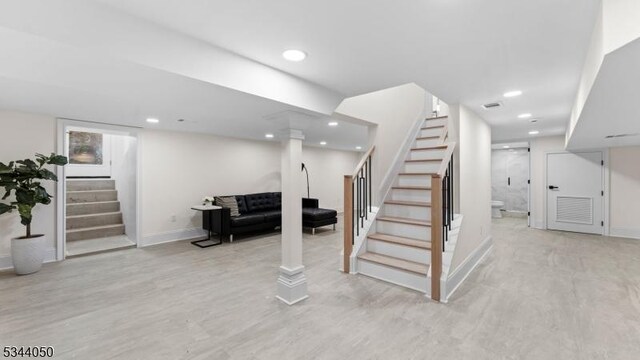 finished below grade area with recessed lighting, stairway, and baseboards