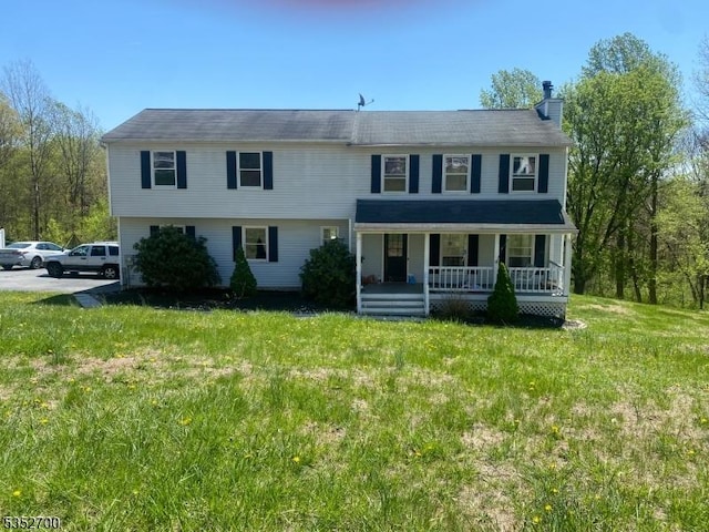 view of front of property featuring covered porch, a chimney, and a front lawn