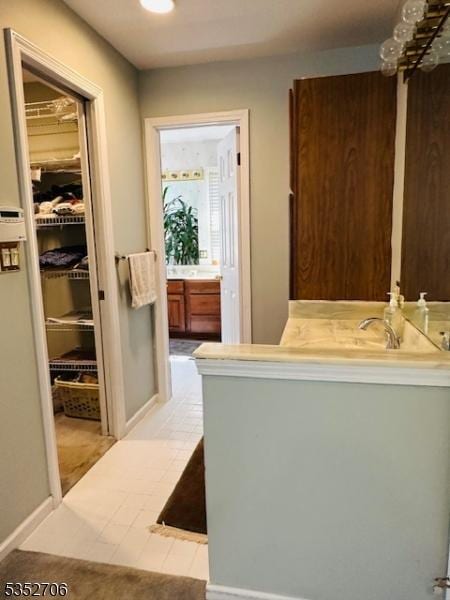 bathroom featuring baseboards, vanity, and recessed lighting
