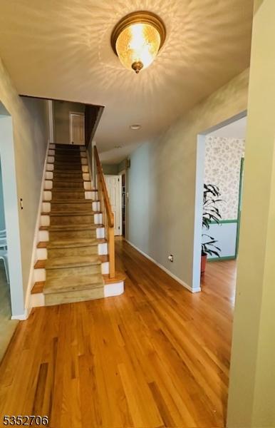 stairway featuring wood finished floors and baseboards