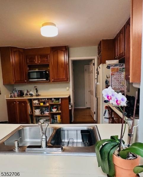 kitchen with light countertops and freestanding refrigerator