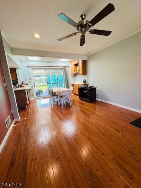 dining area featuring dark wood-style flooring, visible vents, baseboards, and ceiling fan