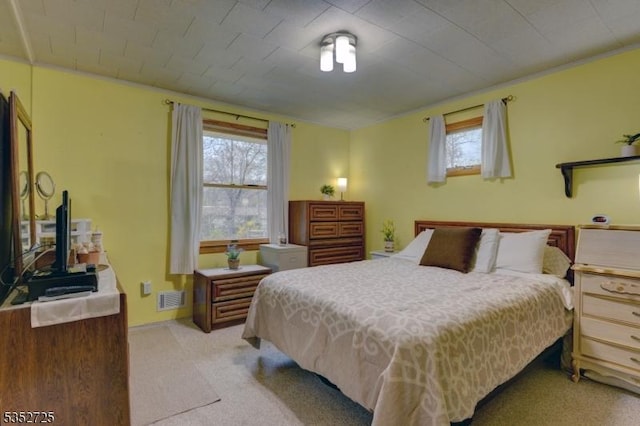 bedroom with light carpet, multiple windows, and visible vents