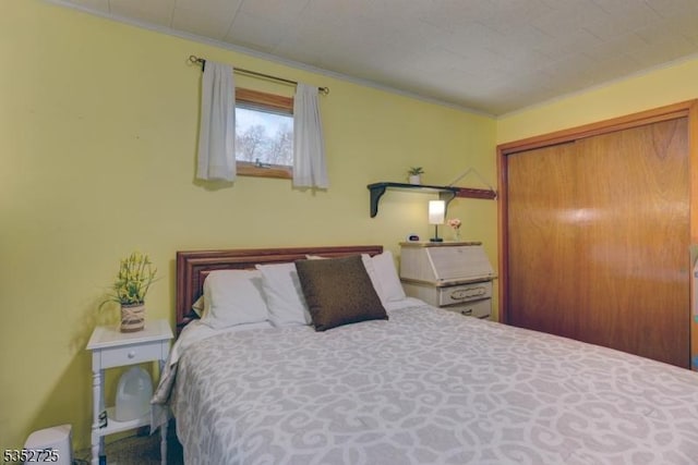 bedroom with ornamental molding and a closet