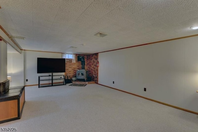 unfurnished living room with light carpet, baseboards, and a wood stove
