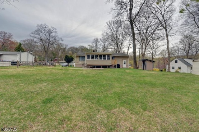 view of yard with an outdoor structure, a sunroom, and a storage shed