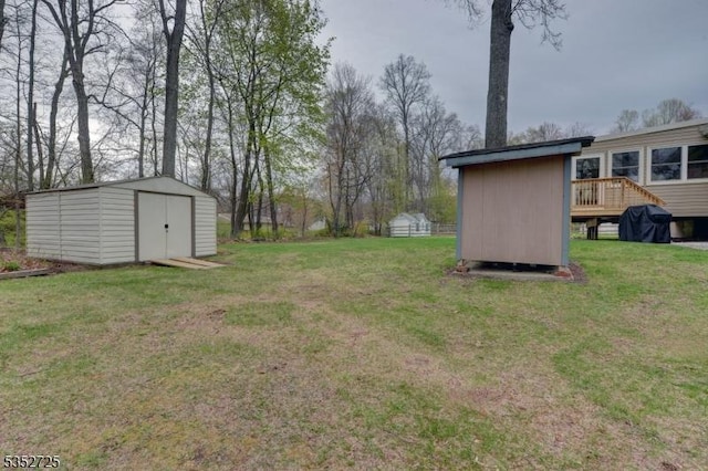 view of yard with a storage shed, an outbuilding, and a deck