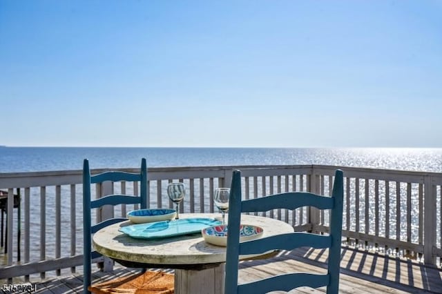wooden deck with outdoor dining space and a water view
