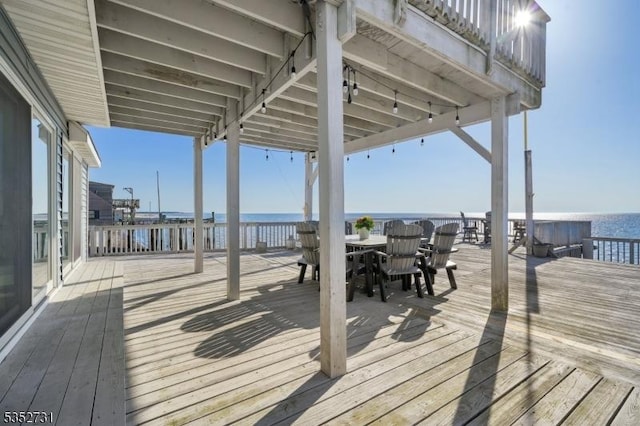 wooden deck featuring a water view and outdoor dining area