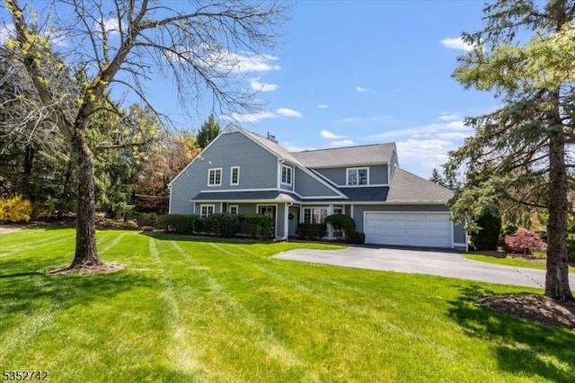 view of front of property featuring a garage, a front lawn, and driveway