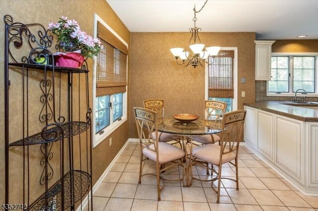 dining area featuring an inviting chandelier, light tile patterned floors, and baseboards