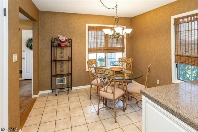 dining room featuring baseboards, light tile patterned floors, and a notable chandelier
