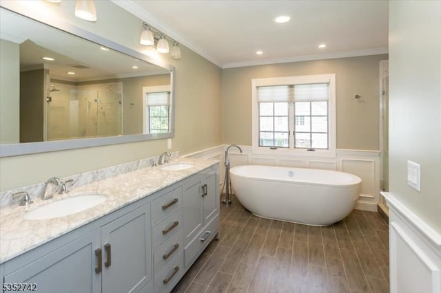 full bath with a sink, wainscoting, and a wealth of natural light