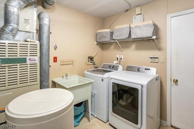 washroom featuring a sink, tile patterned flooring, laundry area, and washing machine and dryer
