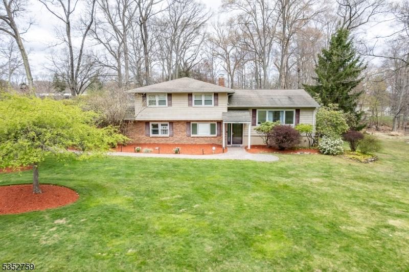 20 Brooklawn Dr, Parsippany-Troy Hills Twp, NJ 07950 - back of house featuring a chimney, brick siding, and a yard