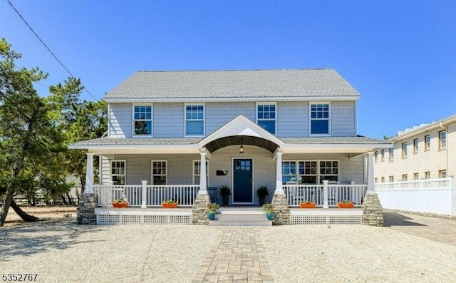 2210 Atlantic Ave, Long Beach Twp, NJ 08008 - view of front facade with roof with shingles, fence, and covered porch