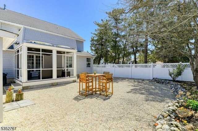 2210 Atlantic Ave, Long Beach Twp, NJ 08008 - exterior space featuring outdoor dining space, a fenced backyard, and a sunroom