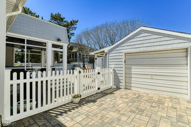 2210 Atlantic Ave, Long Beach Twp, NJ 08008 - view of home's exterior featuring a detached garage, fence, and a sunroom