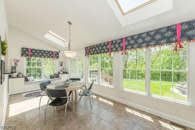 dining room with a skylight, healthy amount of natural light, lofted ceiling, and baseboards