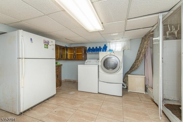 laundry area with washer and clothes dryer, laundry area, and light tile patterned floors
