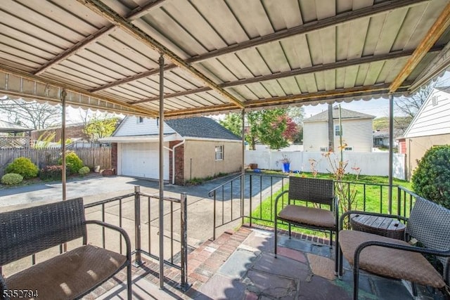 view of patio featuring an outbuilding, a fenced backyard, and driveway