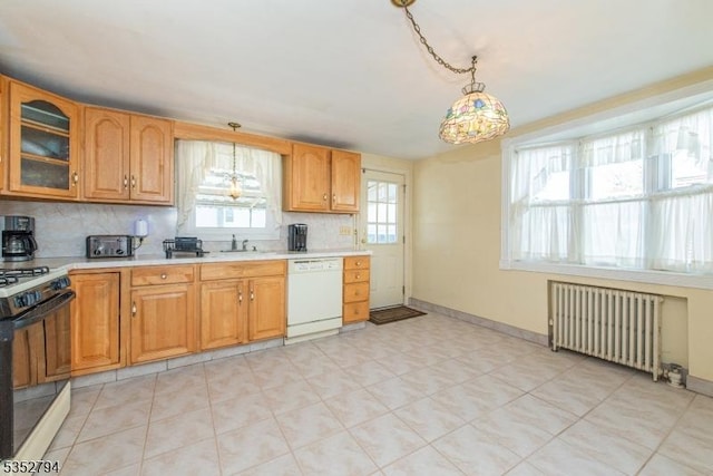 kitchen featuring radiator, decorative backsplash, white dishwasher, gas stove, and light countertops
