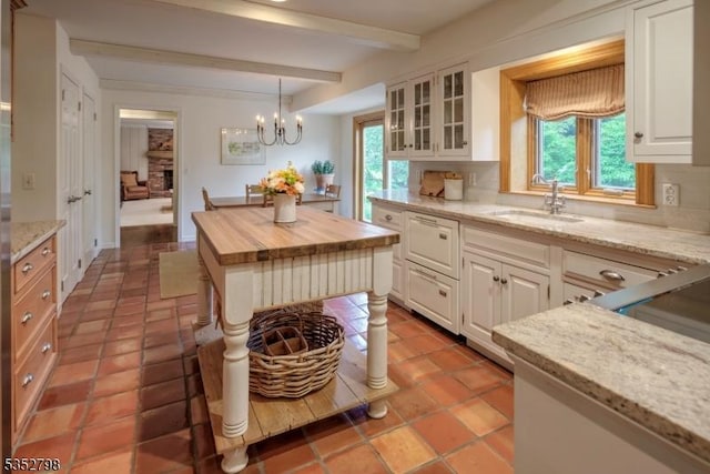 199 W Springtown Rd, Washington Twp, NJ 07853 - kitchen featuring butcher block countertops, a sink, beamed ceiling, plenty of natural light, and white cabinetry