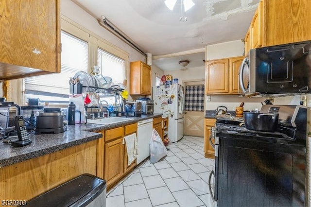 kitchen with a ceiling fan, light tile patterned flooring, a sink, and appliances with stainless steel finishes