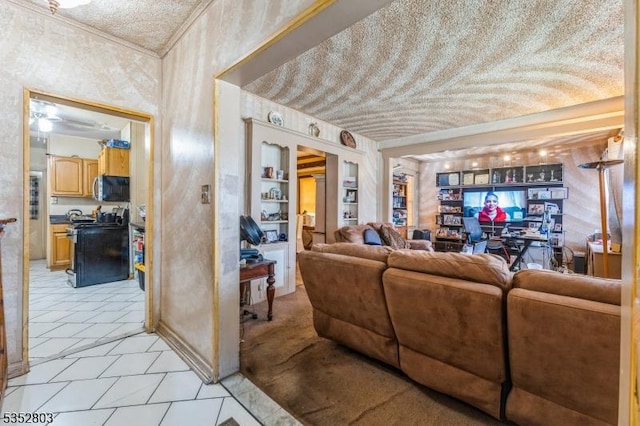 living area with light tile patterned floors, built in shelves, wallpapered walls, and a textured ceiling