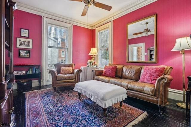living area with ceiling fan, baseboards, and ornamental molding